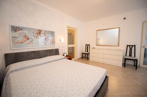 ガルドーネ・リヴィエラにあるAppartamento serenaのベッドルーム1室(ベッド1台付)が備わります。壁には絵画が飾られています。