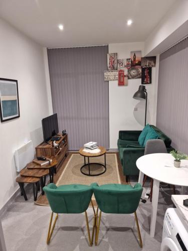 uma sala de estar com um sofá verde e uma mesa em Home away from home em Brierley Hill