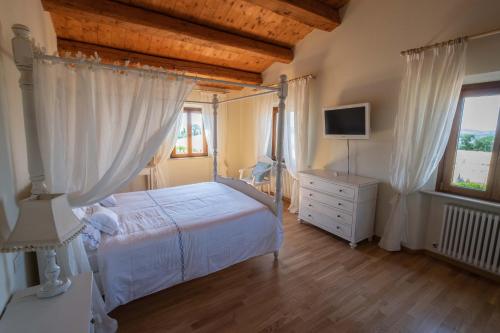a bedroom with a bed and a dresser and a television at B&B La Casa del Gallese in Sorbolongo