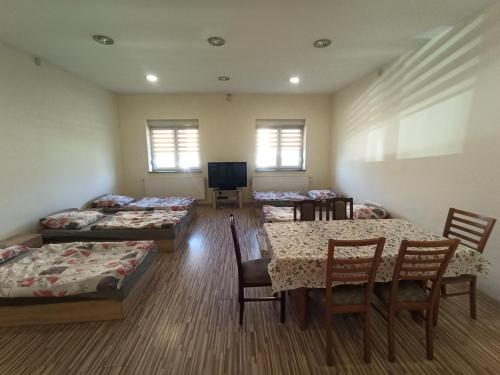 a room with three beds and a table and chairs at Mieszkanie na Wsi in Targowagórka