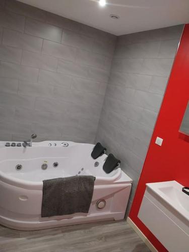 La salle de bains est pourvue d'une baignoire blanche et d'un lavabo. dans l'établissement La maison du centre-ville, à Chagny