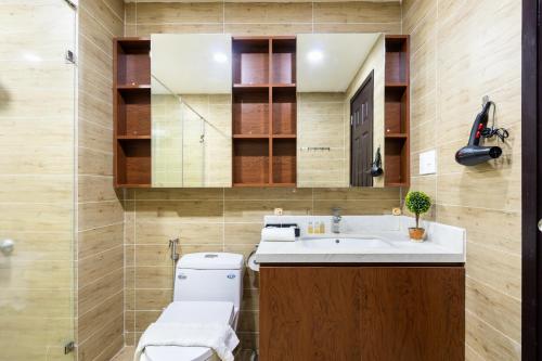 a bathroom with a toilet and a sink and a mirror at Lena Condotel in Ho Chi Minh City