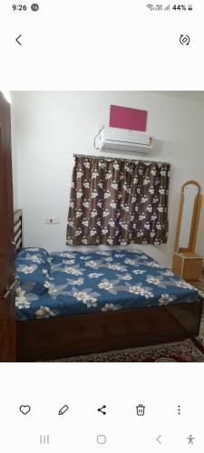 a bedroom with a bed and a window with a bedspread at Gunjan Cottage in Deoghar