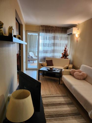 a living room with a couch and a table at St. Vlas apartment in Sveti Vlas