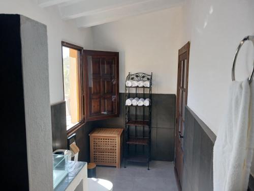 a bathroom with a sink and a shelf with cups at Casa rural los Cerezos in Albox