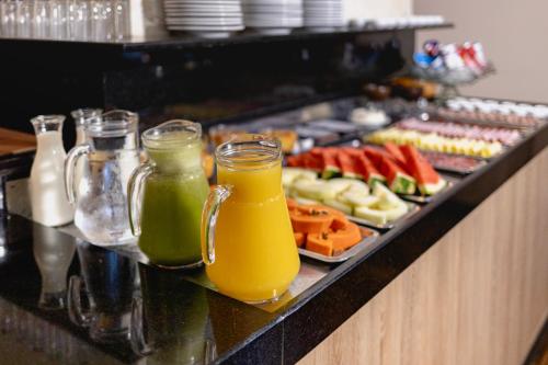a buffet with two glasses of juice and a tray of fruit at Hotel Petrópolis in Nova Petrópolis