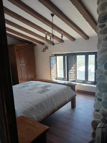a bedroom with a bed in a room with windows at Casa rural los Cerezos in Albox