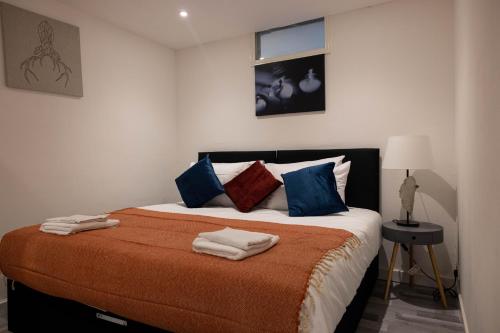 a bedroom with a large bed with towels on it at Pristine Relocation Flat 1 in London