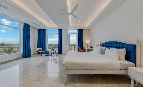 a bedroom with a large bed and blue curtains at Highland Club with Swimming Pool-GYM in Kolhapur