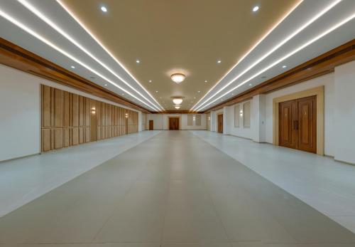 an empty corridor with a large room with lights on the ceiling at Highland Club with Swimming Pool-GYM in Kolhapur