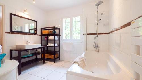 La salle de bains blanche est pourvue d'une baignoire et d'un lavabo. dans l'établissement Camping la Croix du Sud, à Saint-Tropez