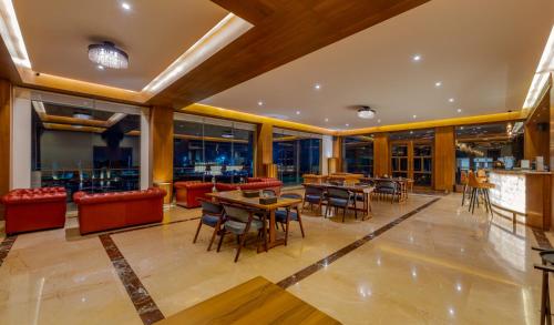 a restaurant with tables and chairs and windows at Highland Club with Swimming Pool-GYM in Kolhapur