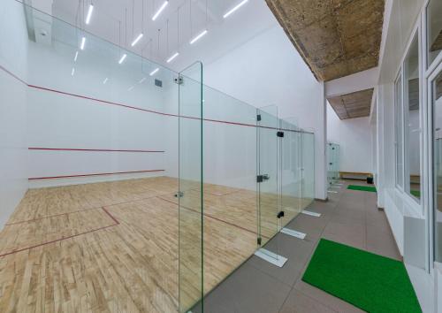 a glass partition in a room with a tennis court at Highland Club Kolhapur in Kolhapur