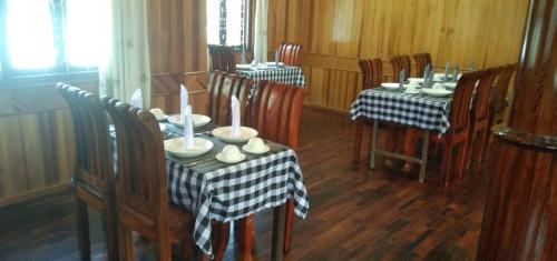 a dining room with tables and chairs with candles on them at Sipanya Guesthouse in Muang Phônsavan