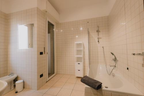Arena Luxury Apartment في فيرونا: حمام مع حوض استحمام ودش ومغسلة