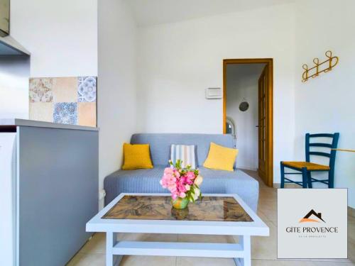 un salon avec un canapé bleu et une table dans l'établissement Gîte de la Draillette, à Noves