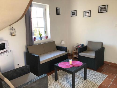 a living room with a couch and a table at La Tour de la Conterie in Beaumont-Village