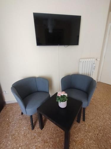 a living room with two chairs and a table with a tv at Appartamento Fiore Roma Cinecittà in Rome