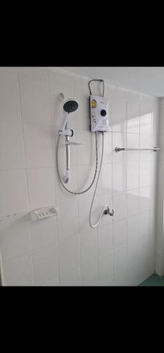 a shower in a bathroom with a shower head at Paradise Bar and Guesthouse 1 in Pattaya South