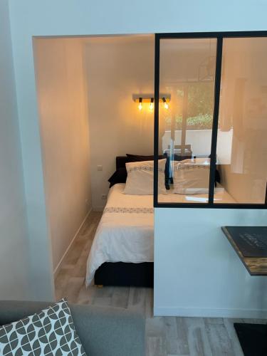 een slaapkamer met een bed en een spiegel bij Studio coin nuit terrasse parking Clim in Nice
