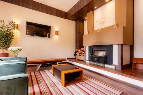 a living room with a fireplace and a couch at Hotel Petrópolis in Nova Petrópolis