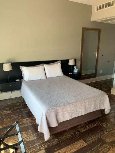 - une chambre avec un lit avec deux oreillers et un miroir dans l'établissement Northport Inn Boutique Hotel R207, à Northport