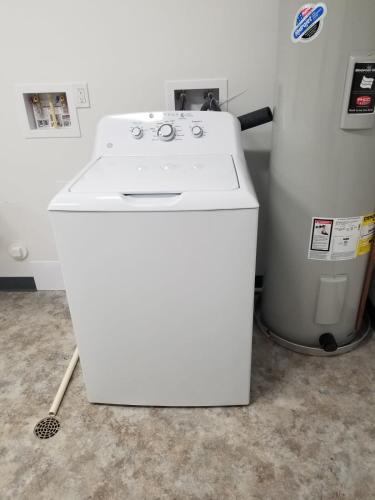 a white washing machine sitting next to a trash can at Condo at The Commons in Traverse City
