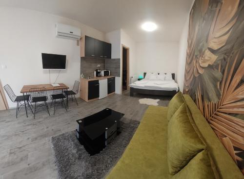 a living room with a couch and a bed at Habán Lux Apartmanház in Hévíz