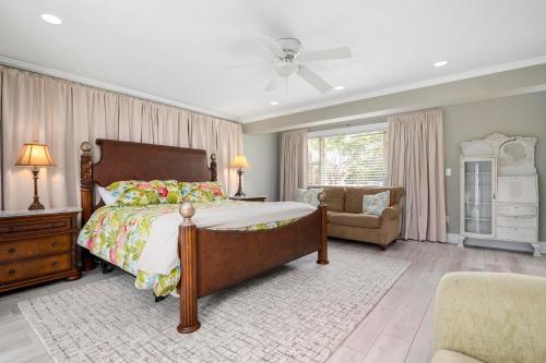 une chambre avec un lit, une chaise et une fenêtre dans l'établissement Coastal Vibes! Tropical heated pool home short drive to the beach, à Bradenton