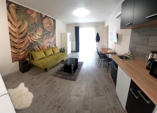 een woonkamer met een bank en een keuken bij Habán Lux Apartmanház in Hévíz