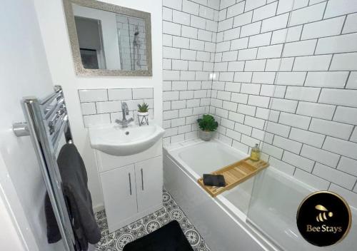 a white bathroom with a sink and a bath tub at Bee Stays - Afton House in Cronton