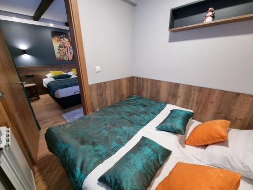 a bedroom with a bed with pillows and a mirror at Alpha lux C520 - Aparthotel Vucko - Privatni apartman in Jahorina