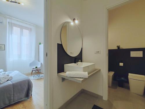 uma casa de banho com um lavatório e um espelho na parede em Alilè em Sassari