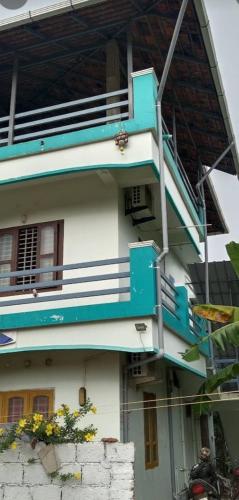 a building with a blue staircase on the side of it at Heaven Homestay in Alleppey