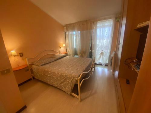 ヴィアレッジョにあるViareggio Casa con terrazzaのベッドと大きな窓のある寝室