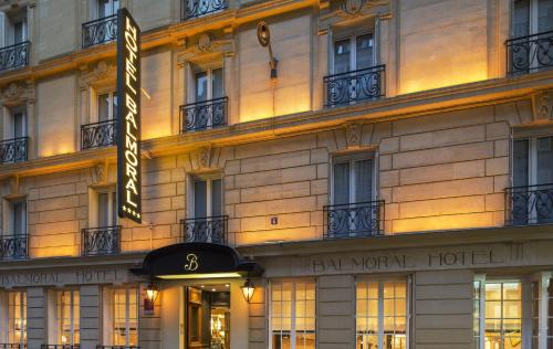 un bâtiment d'hôtel avec un panneau devant lui dans l'établissement Balmoral Champs Elysées, à Paris