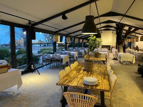 a restaurant with wooden tables and chairs and tables and windows at PİA MARE OTEL in Gündüzlü