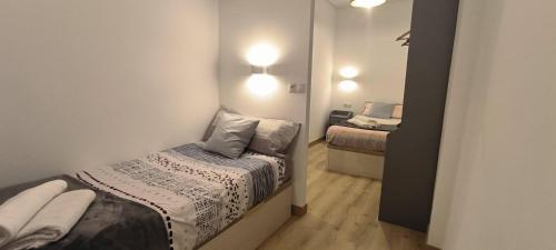 a small bedroom with a bed and a mirror at Apartamento Zabala conoce Bilbao desde dentro in Bilbao