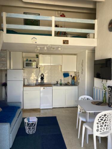 une cuisine et un salon avec un canapé et une table dans l'établissement maison climatisée à 500m de la plage dans résidence, à Saint Cyprien Plage