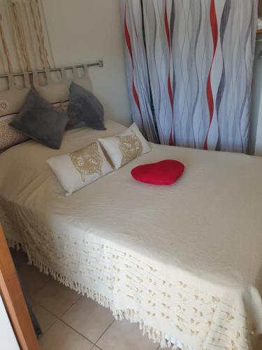 - un lit avec un cœur rouge au-dessus dans l'établissement Location vacances, à Argelès-sur-Mer