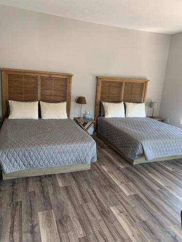 2 letti in una camera da letto con pavimenti in legno di Northport Inn Boutique Hotel Room 8 a Northport
