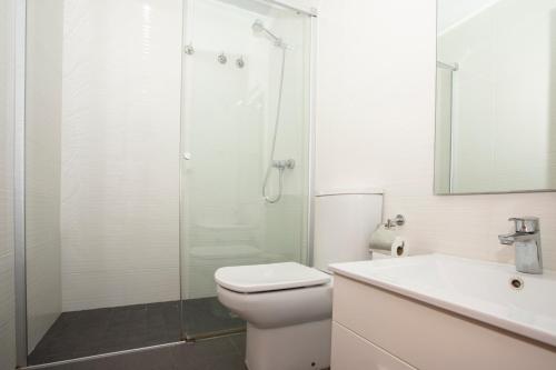 uma casa de banho com um chuveiro, um WC e um lavatório. em Bright Sunny Apartment in central Exiample em Barcelona