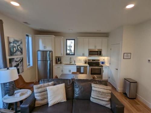 a living room with a leather couch and a kitchen at Capri Condo in Downtown Traverse City in Traverse City