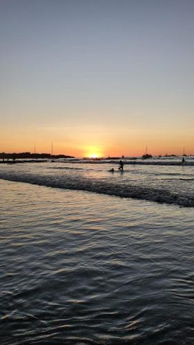 a group of people surfing in the ocean at sunset at Capri Condo in Downtown Traverse City in Traverse City