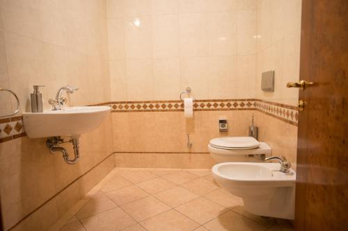 a bathroom with a toilet and a sink at Hotel Golden Palace in Göd