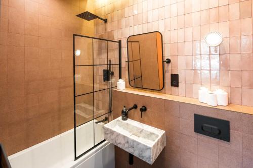 a bathroom with a sink and a mirror at Beautiful 3BD Designer Apartment in London