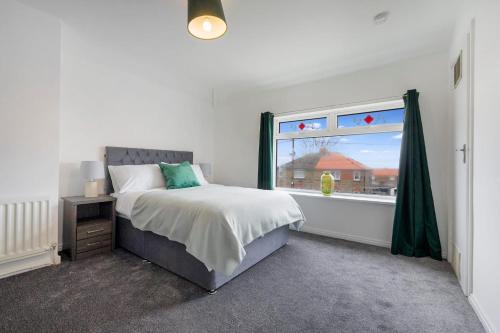 1 dormitorio con cama y ventana en Stylish home Near Durham Heritage Coast Sleeps 5 en Durham