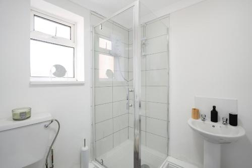 a white bathroom with a shower and a sink at Stylish home Near Durham Heritage Coast Sleeps 5 in Durham