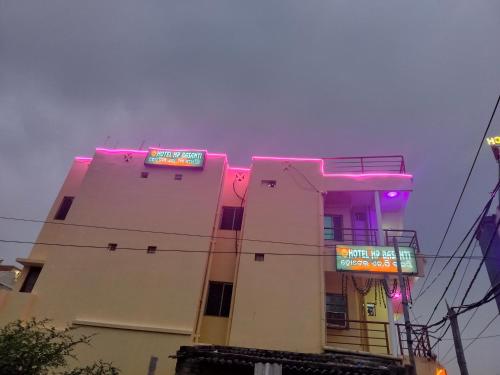a building with neon signs on the side of it at Hotel basanti in Puri