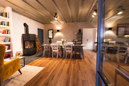 a living room with a table and a fireplace at VILLA TOURI - Touri Alpesi Birtok in Bozsok